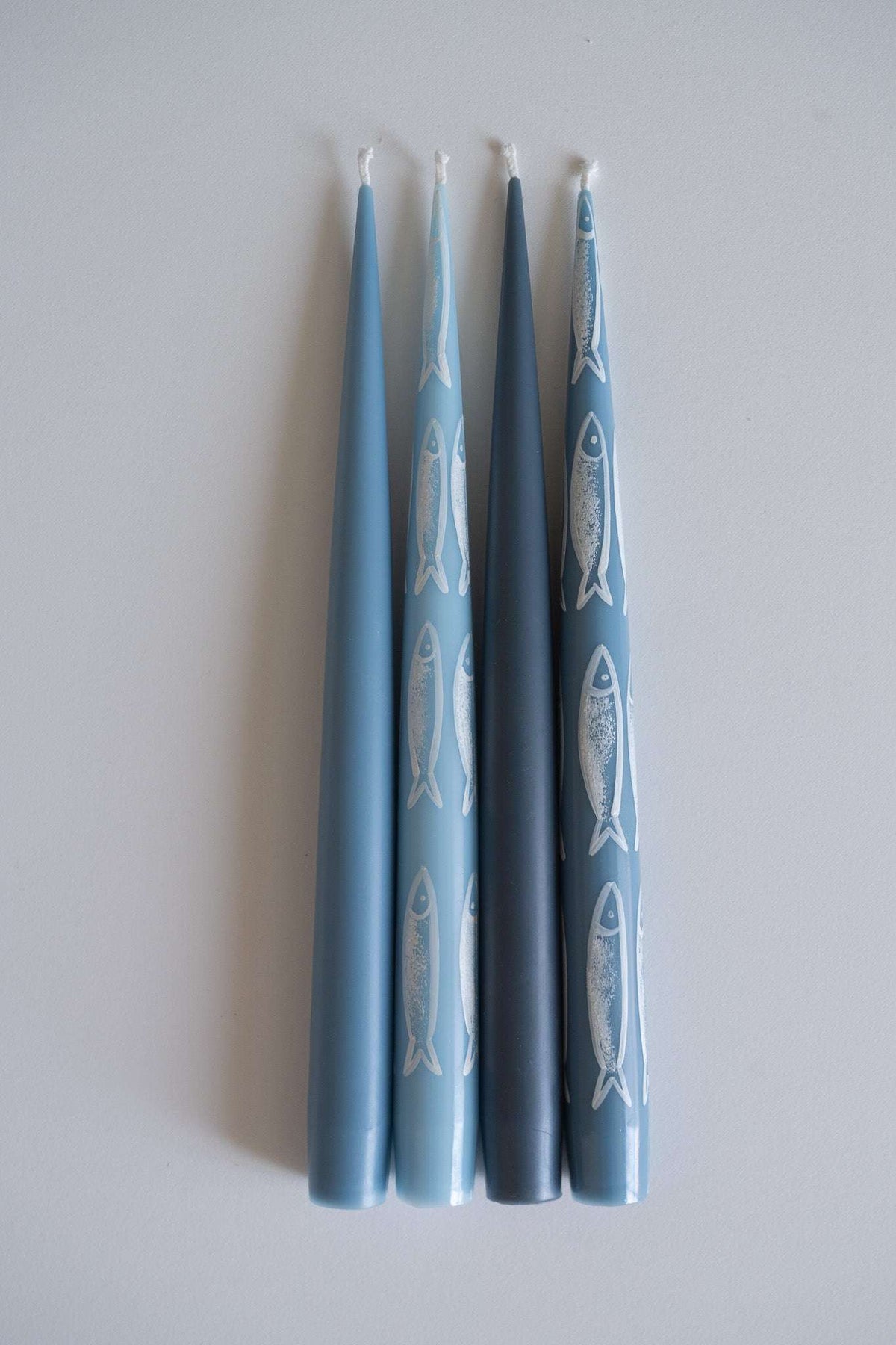 Hand-painted taper candle set with blue sardine illustrations for coastal decor