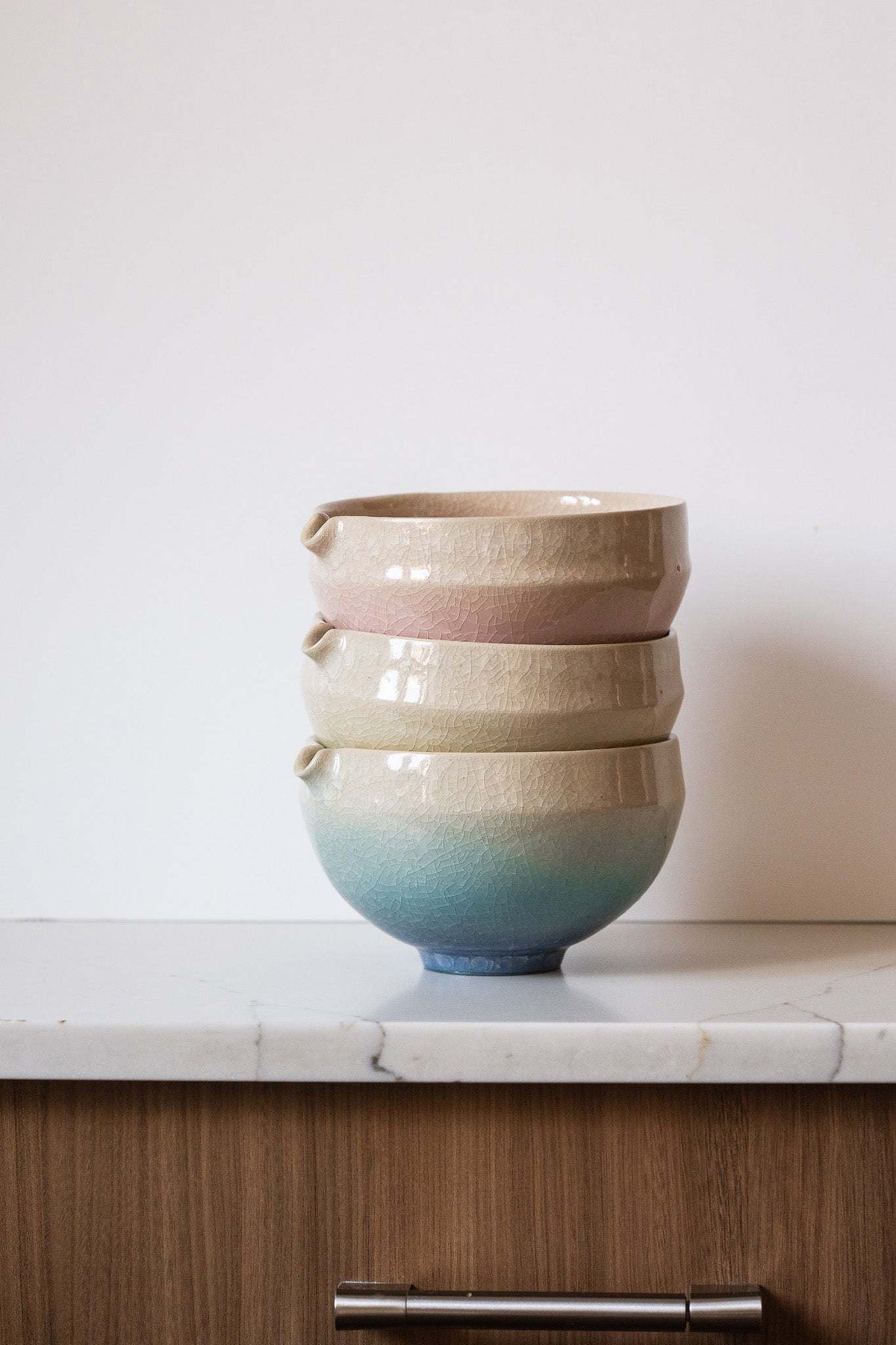 Ceramic Matcha Bowl set of three stacked stoneware bowls with spouts, glossy cream, blush pink, and blue-green glaze gradients.