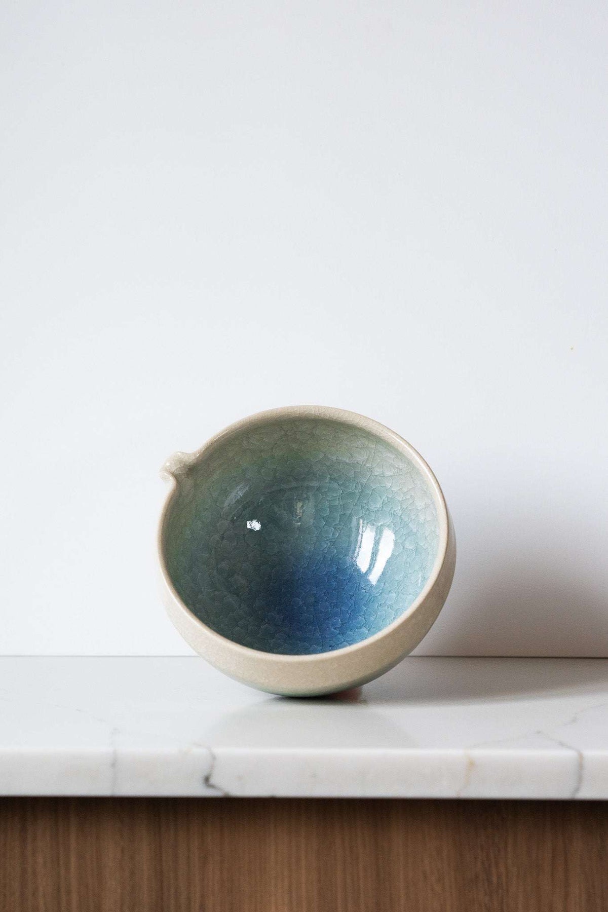 Ceramic Matcha Bowl in sandy cream stoneware with a blue-green gradient glaze, crackle texture, and pouring spout.