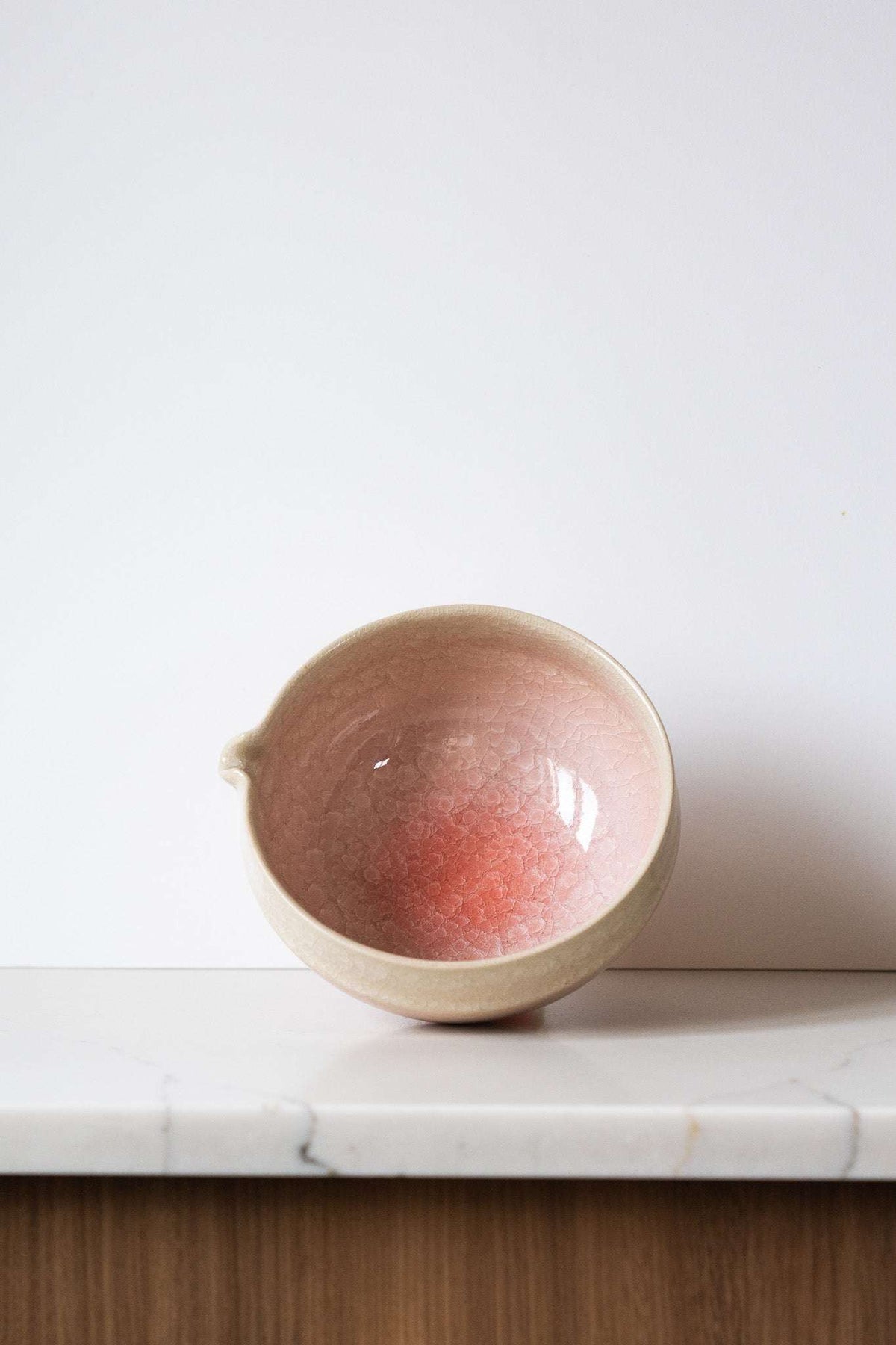 Ceramic Matcha Bowl in sandy cream and blush pink glaze, with a glossy crackle finish and built-in pouring spout.
