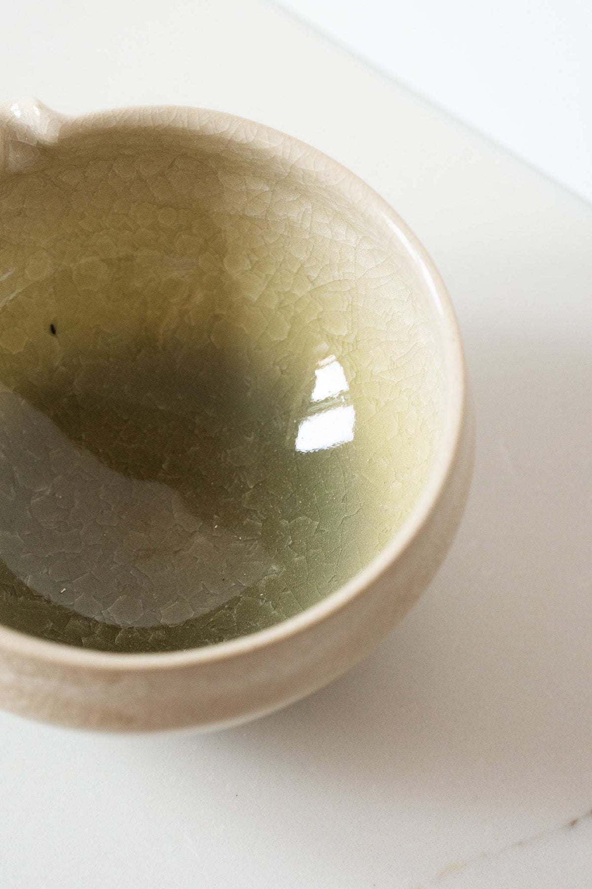 Ceramic Matcha Bowl in pale olive-green glazed stoneware, with a delicate crackle texture and rounded rim.