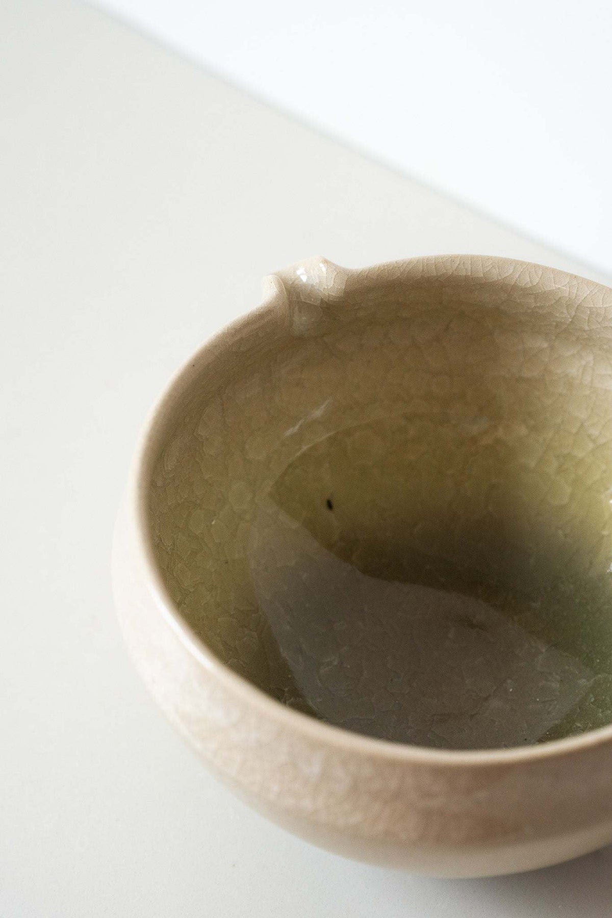 Ceramic Matcha Bowl in sandy beige stoneware with a subtle crackle glaze and small pouring spout.