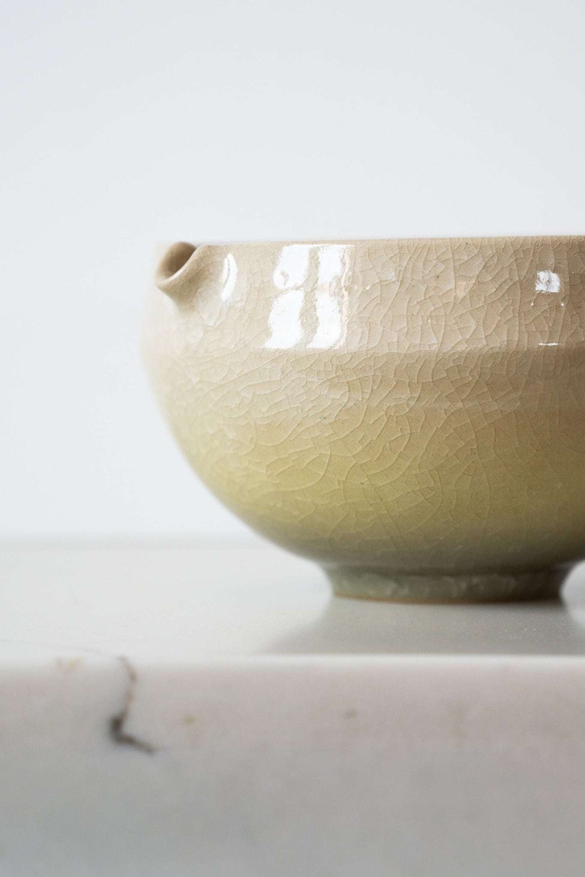 Ceramic Matcha Bowl in pale cream stoneware with a glossy crackle glaze and built-in pouring spout.