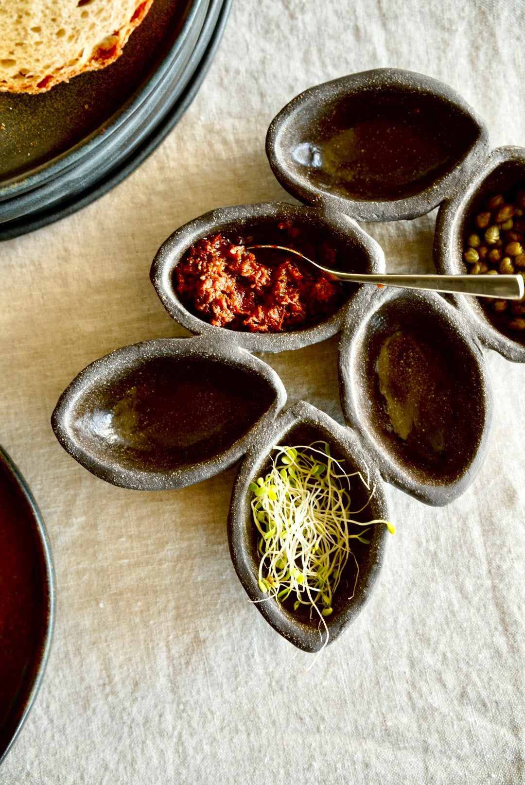 Stoneware Serving Dish in deep earthy brown stoneware, featuring a handmade spiked design with five connected wells.