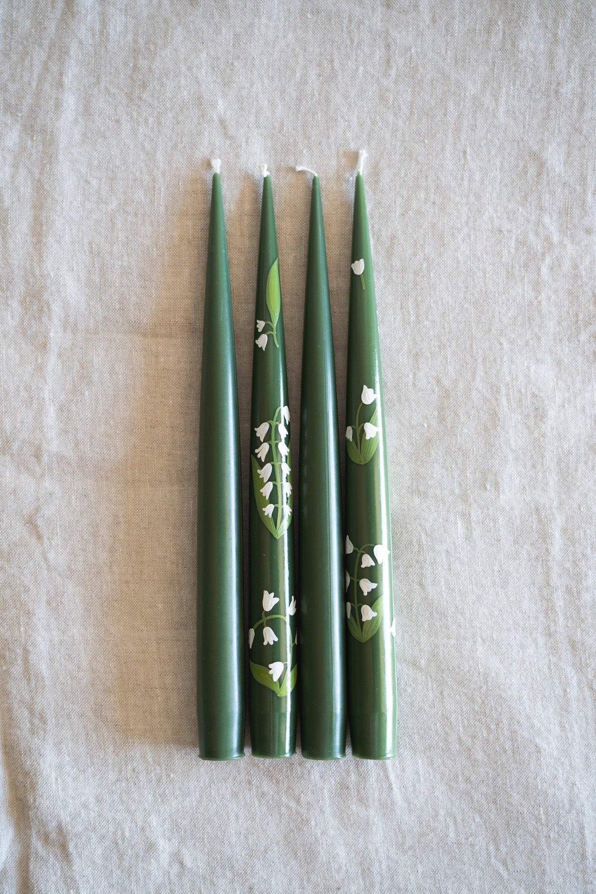 Hand-Painted Taper Candle set in deep green wax, decorated with delicate white hand-painted floral motifs and slim tapered ends.