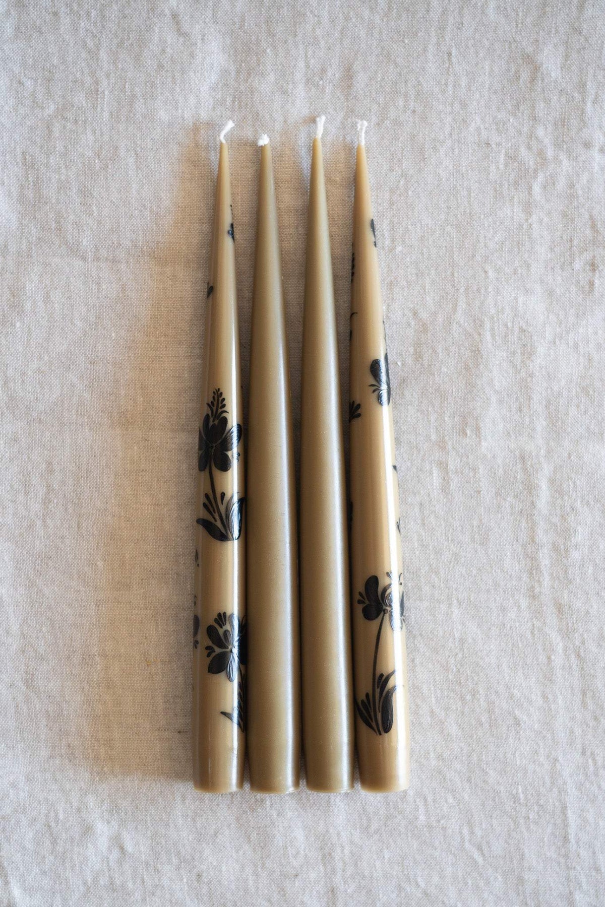 Hand-Painted Taper Candle Set of four slim ivory candles with delicate dark floral hand-painted motifs and white wicks.