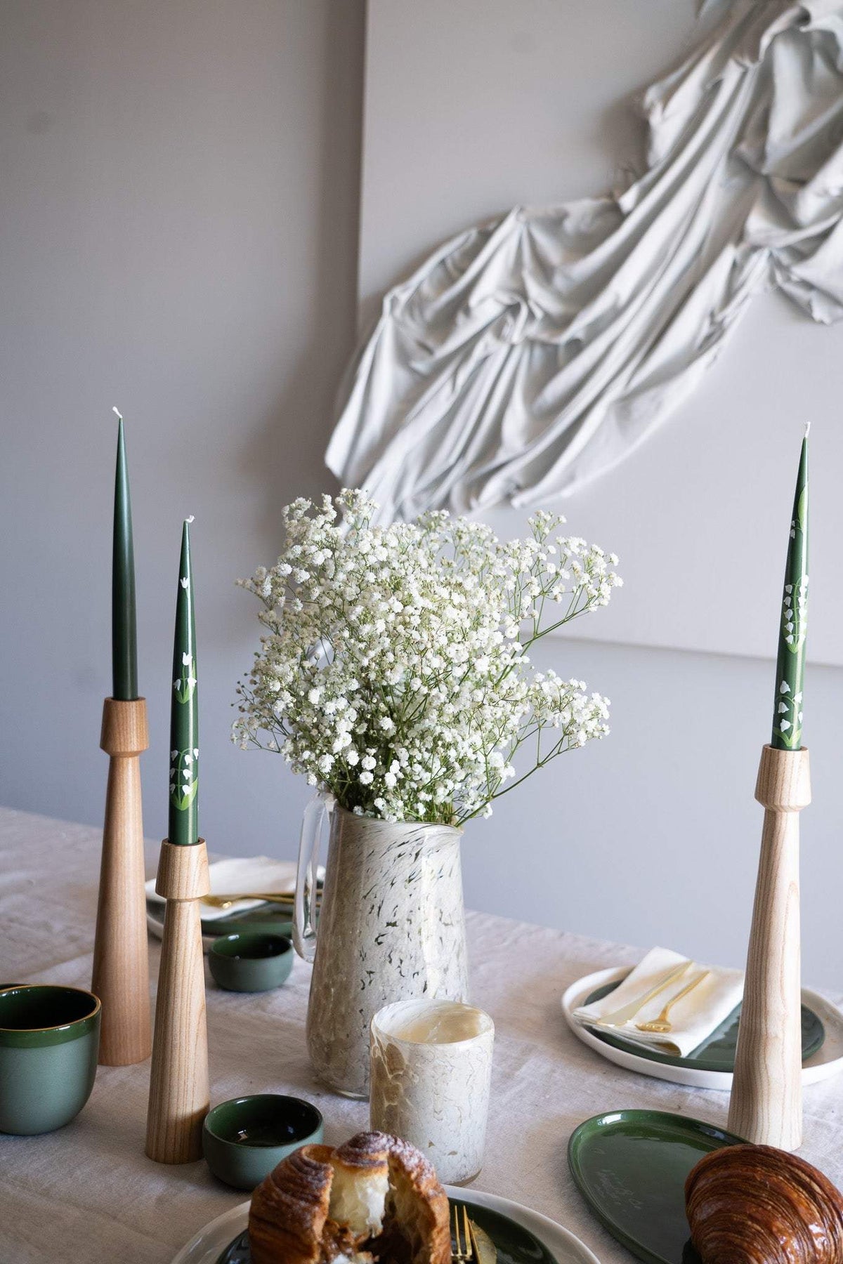 Hand-Painted Taper Candle pair in deep green with delicate white painted details, displayed in wooden holders.
