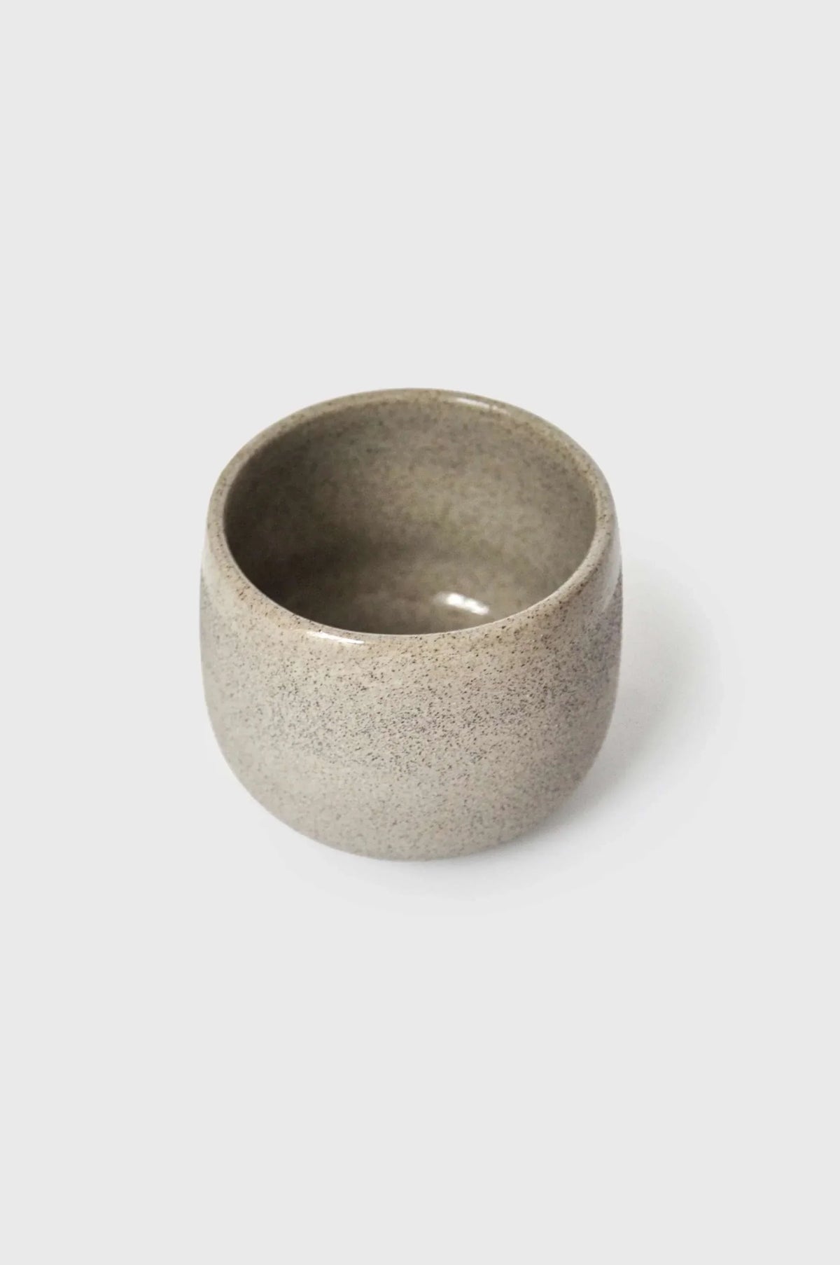 Handmade Stoneware Coffee Cup in speckled gray-beige stoneware, with a rounded shape and dark glazed interior.