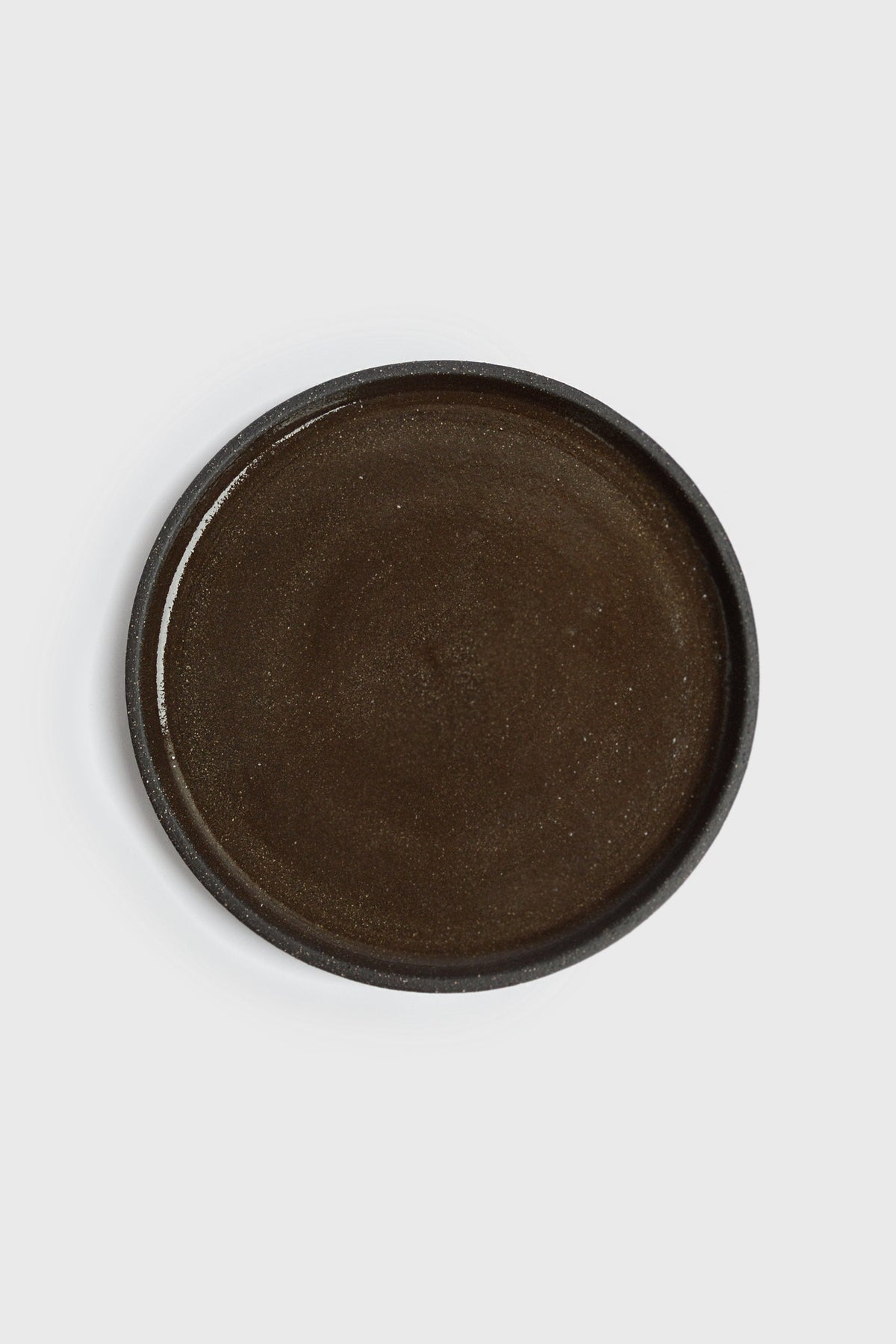 Handmade stoneware dinner plates in pumpernickel color with smooth glazed interior and rough exterior