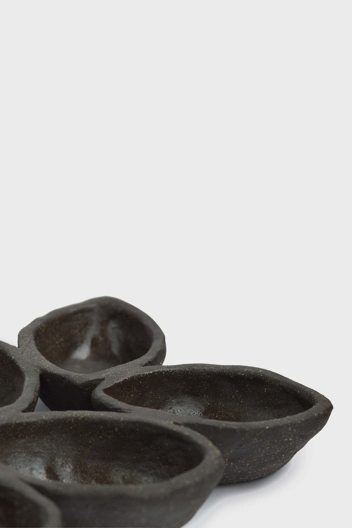 Stoneware Serving Dish in deep charcoal-brown, with a matte speckled finish and sculpted spiked edges.