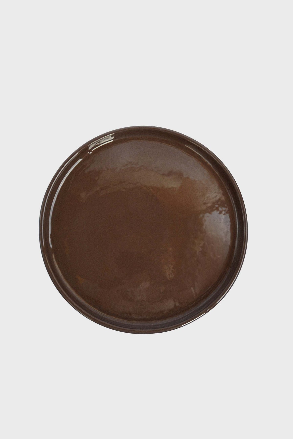 Handmade Blue Porcelain dinner plate with a glossy chocolate-brown glaze and gently raised rim.