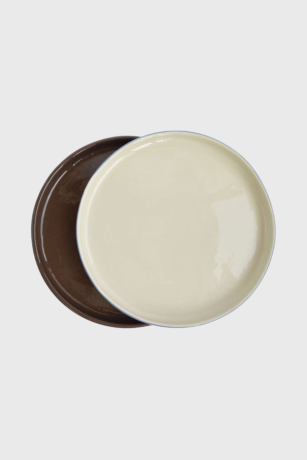 Handmade Blue Porcelain dinner plates with glossy cream interiors, dark chocolate brown exteriors, and delicate blue rims.