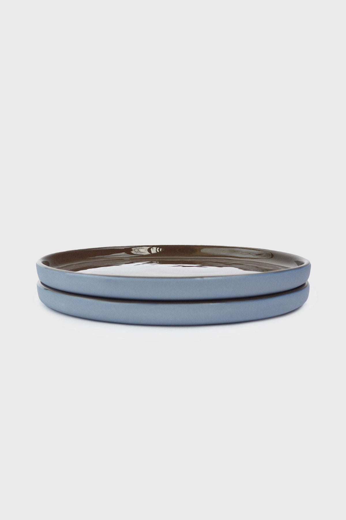 Handmade Blue Porcelain dinner plates with pale blue exteriors and glossy chocolate-brown glazed rims and interiors.
