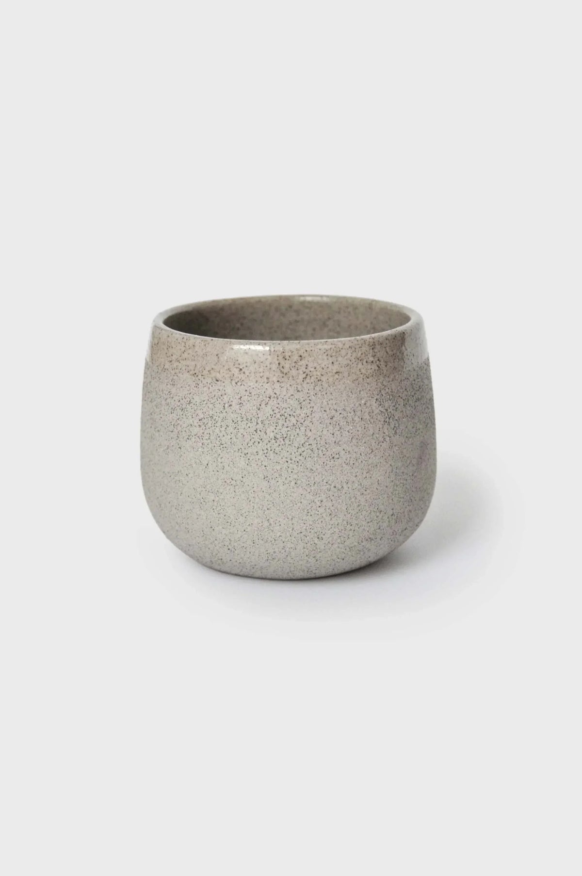 Handmade Stoneware Coffee Cup in speckled gray stoneware, with a rounded shape, matte exterior, and dark glazed interior.