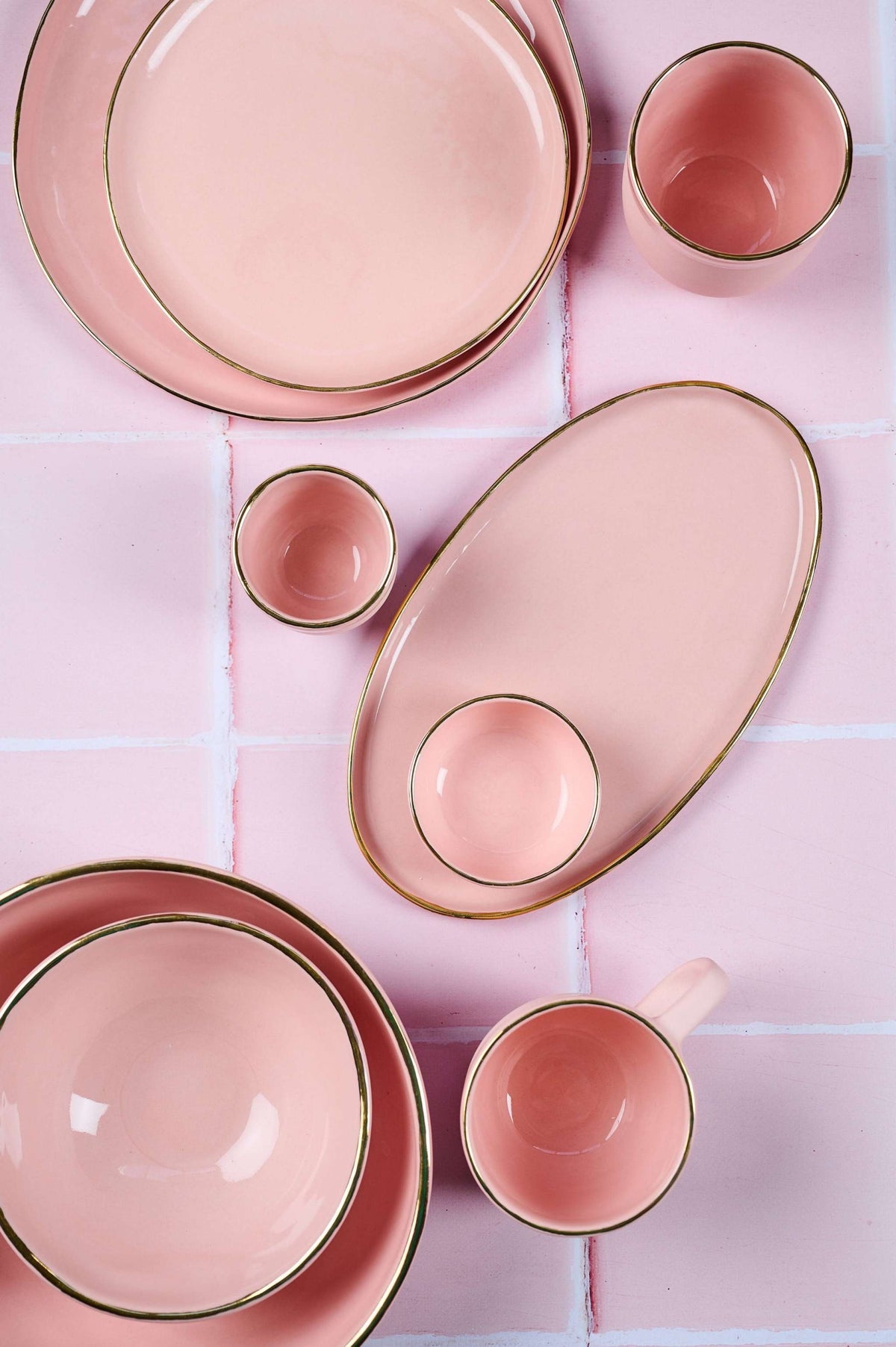 Handmade oval porcelain serving platter in powder pink with gold rim and organic edges