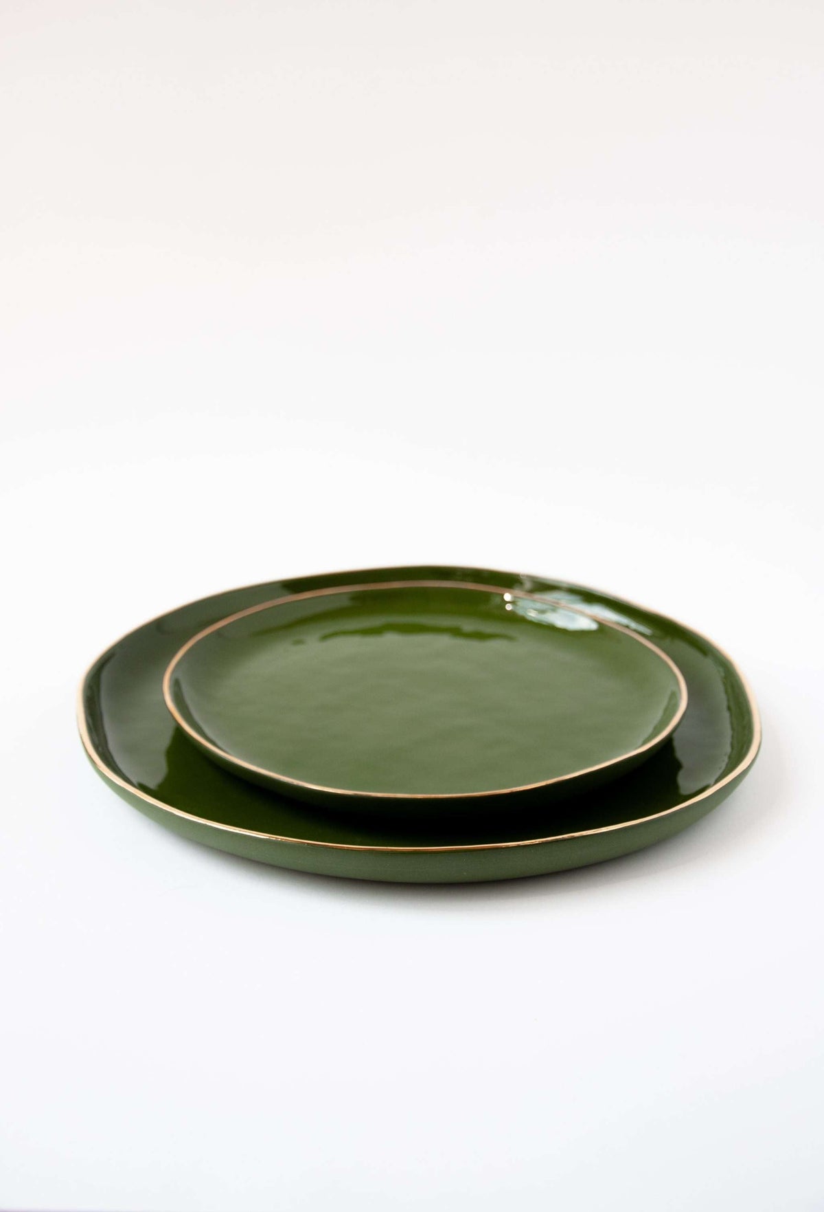 Handmade porcelain dinner plates with gold rim and glossy green finish