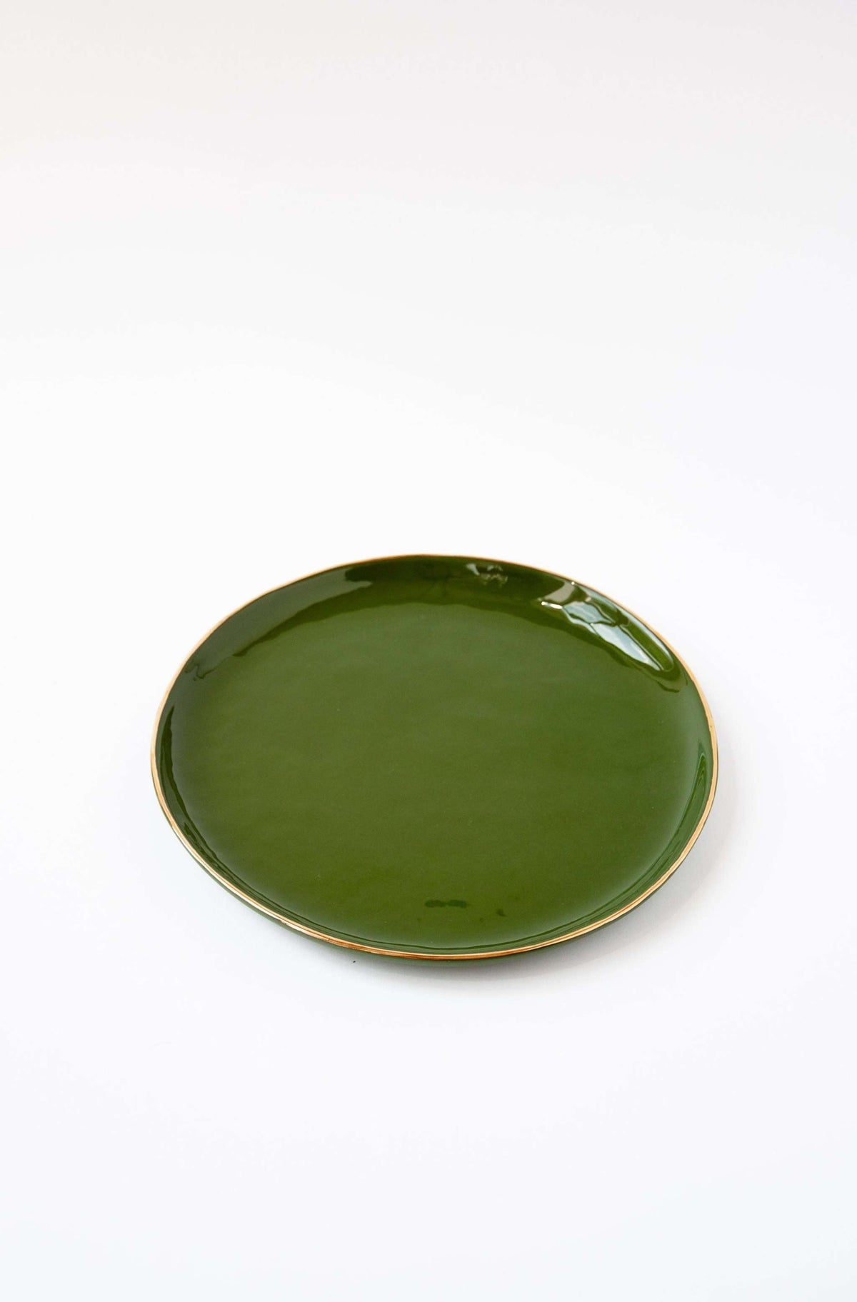 Handmade porcelain dinner plate with gold rim and shiny green glaze