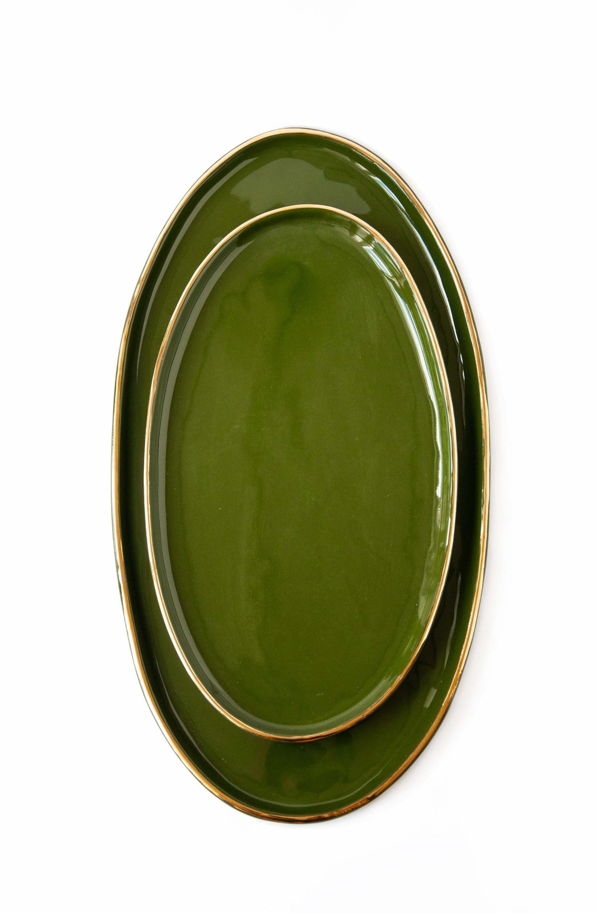 Green porcelain oval serving platter with gold rim and organic round edges
