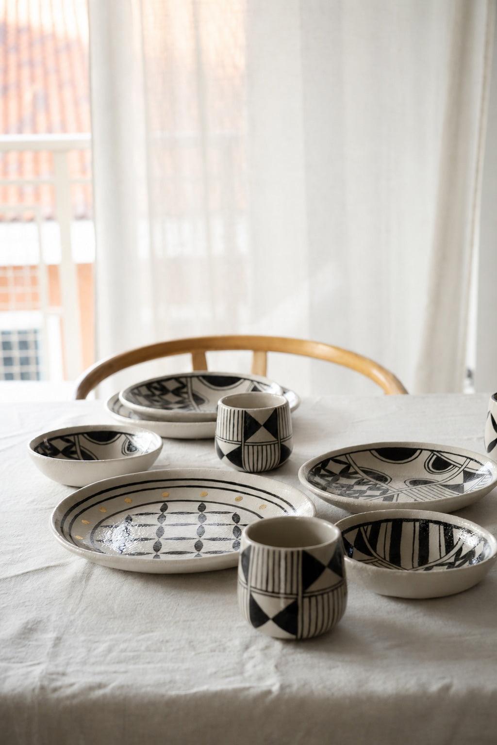 Hand Painted Stoneware Salad Plate in cream with bold black geometric folk motifs, glossy glaze and an irregular rim.