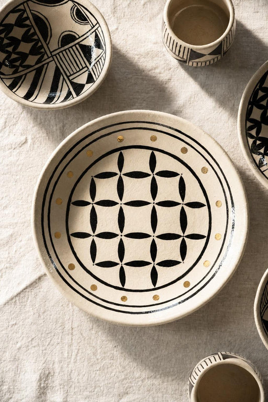 Hand Painted Stoneware Salad Plate in cream ceramic, with a bold black geometric motif, gold dots, and an irregular rim.