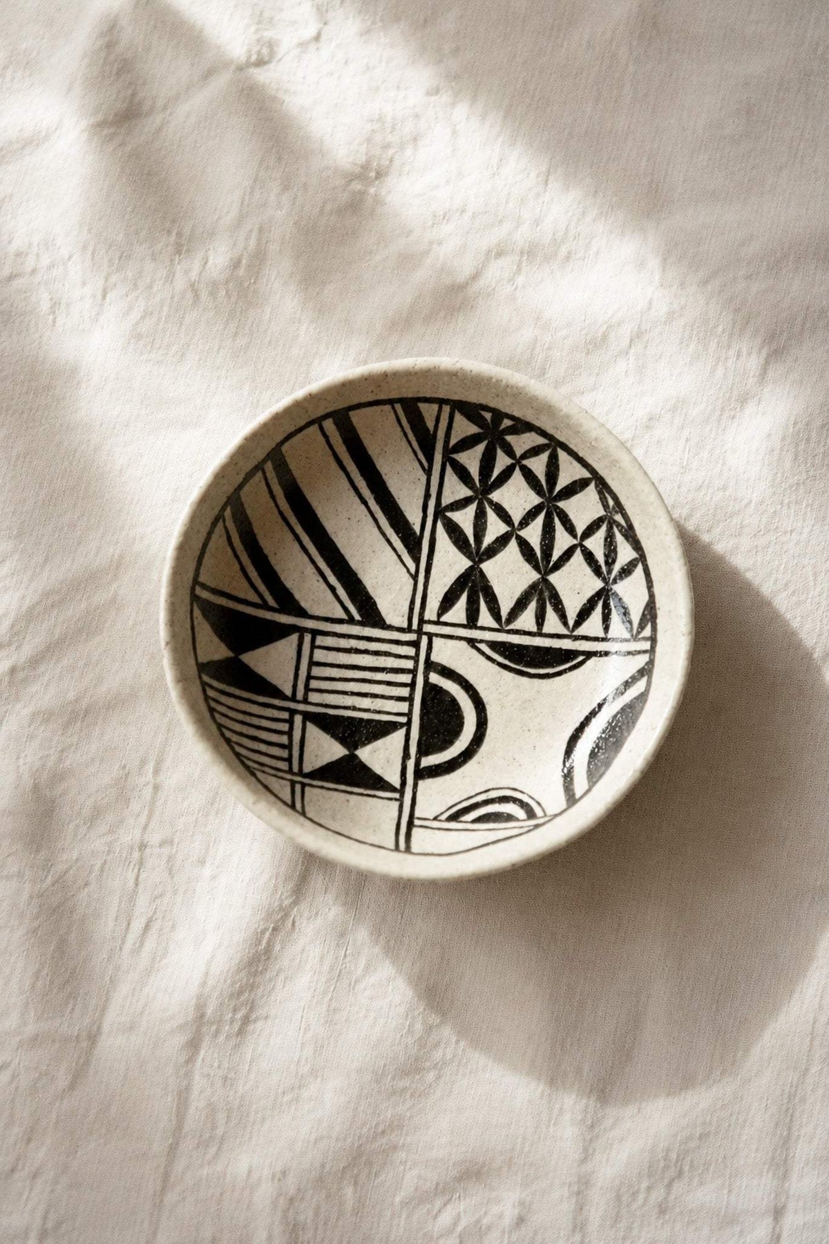 Hand Painted Stoneware Salad Plate in cream with bold black geometric motifs, glossy glaze, and an irregular handmade rim.