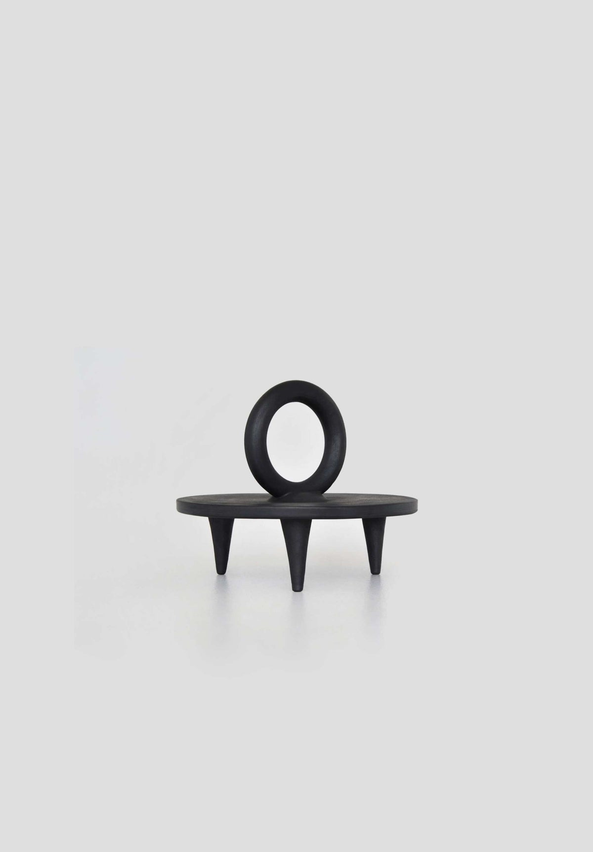 Small black smoked ceramic pedestal platter handcrafted in Ukraine by Danuta Kril with unique smoke-fired markings