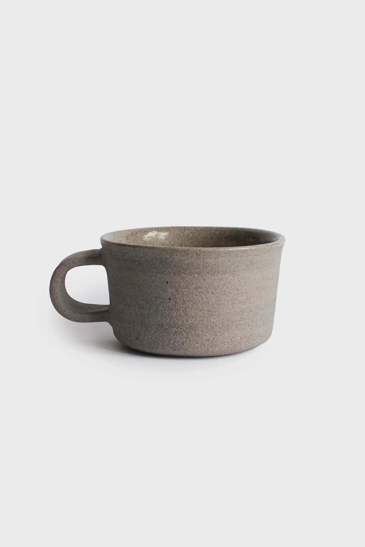 Handmade Stoneware Coffee Mug in speckled gray stoneware, with a wide open shape and rounded handle.
