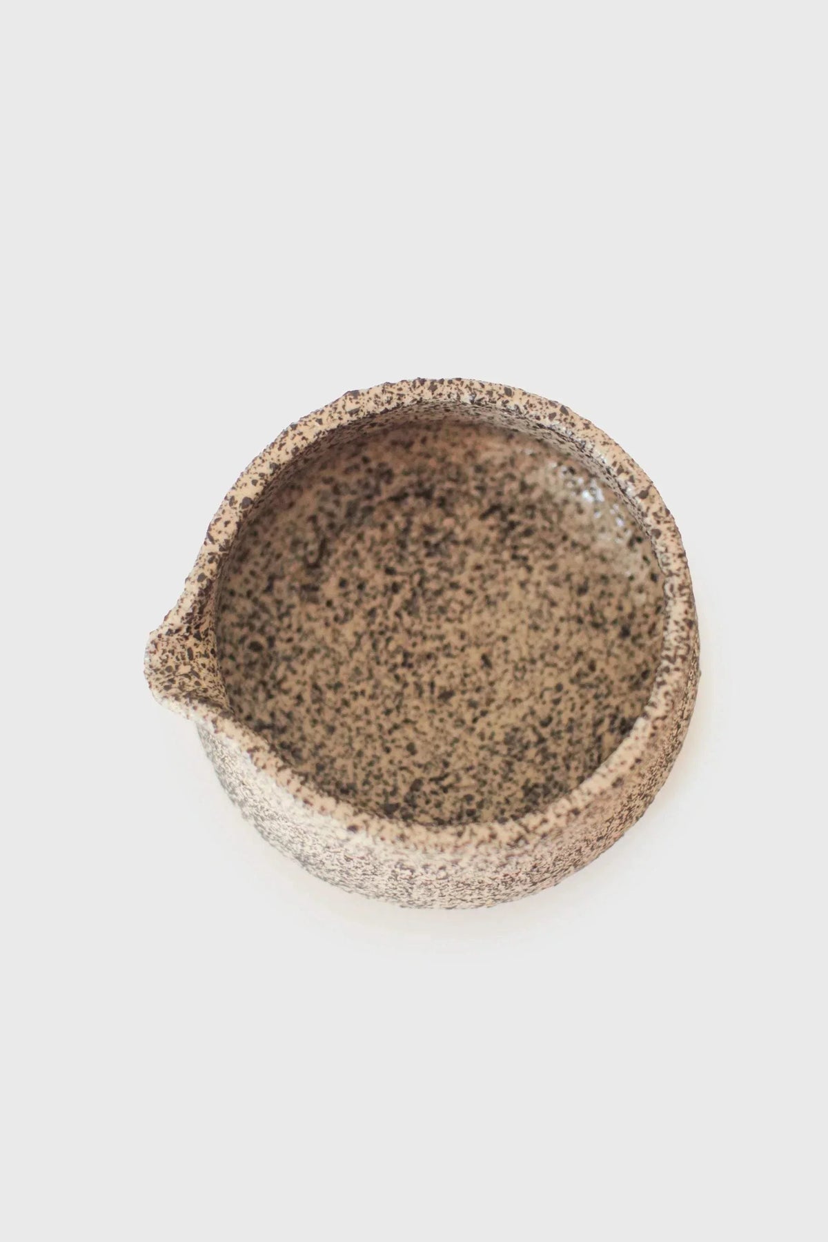 Handmade Stoneware Matcha Bowl in warm beige stoneware with dense dark speckles and a subtly irregular rim.
