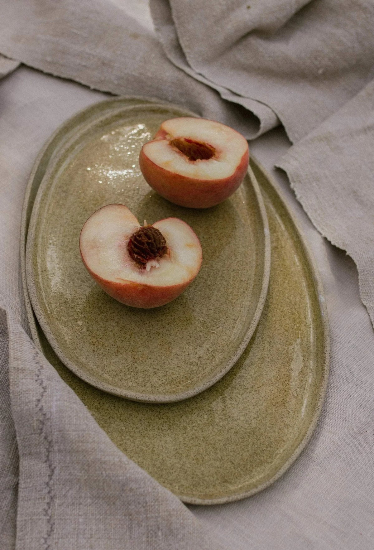 Handmade Stoneware serving platter with a muted olive-brown speckled glaze, oval shape and subtly raised rim.