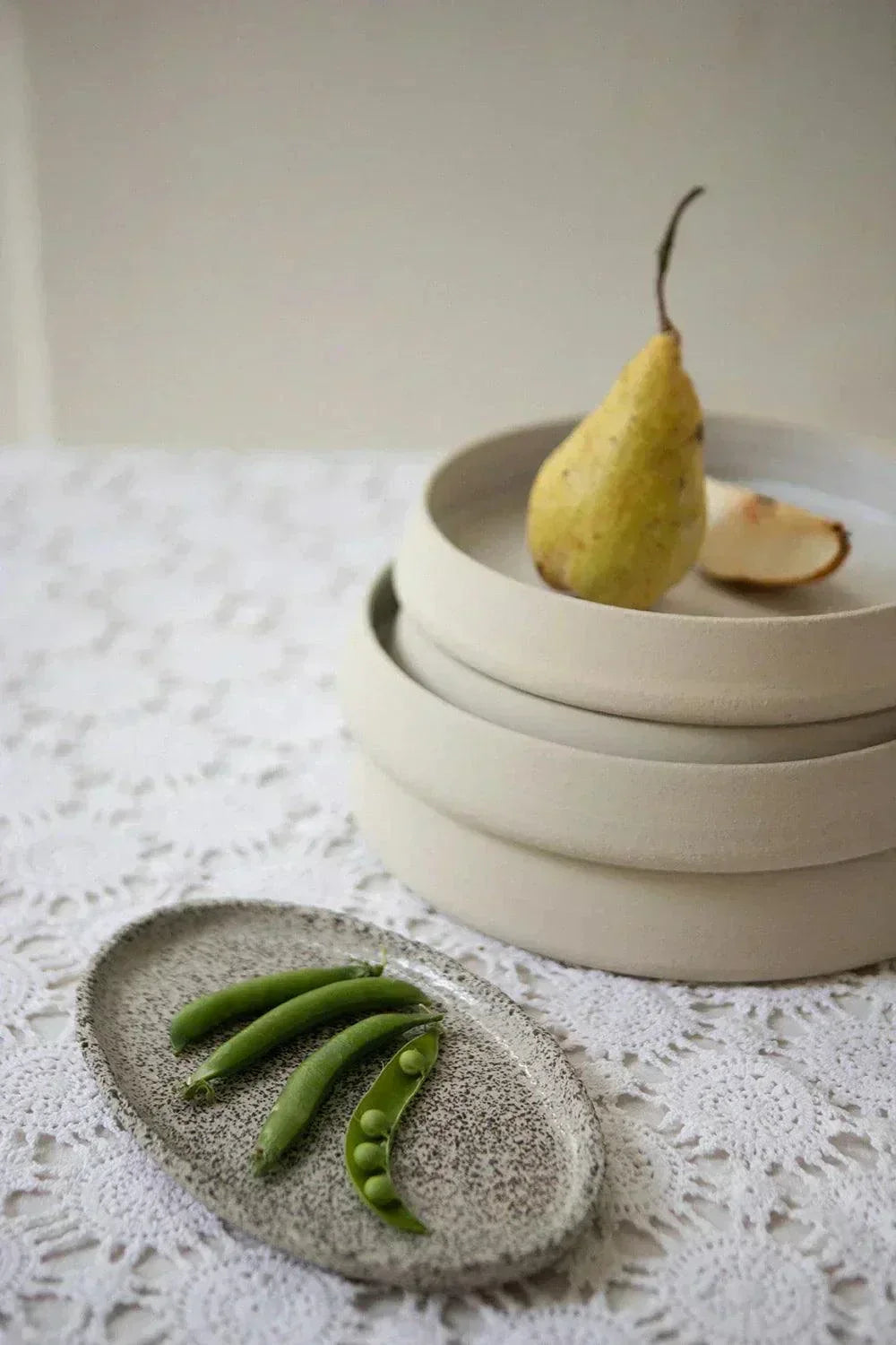 Large Serving Platter in oval stoneware with a cream base, dense black speckles, and a softly raised rim.