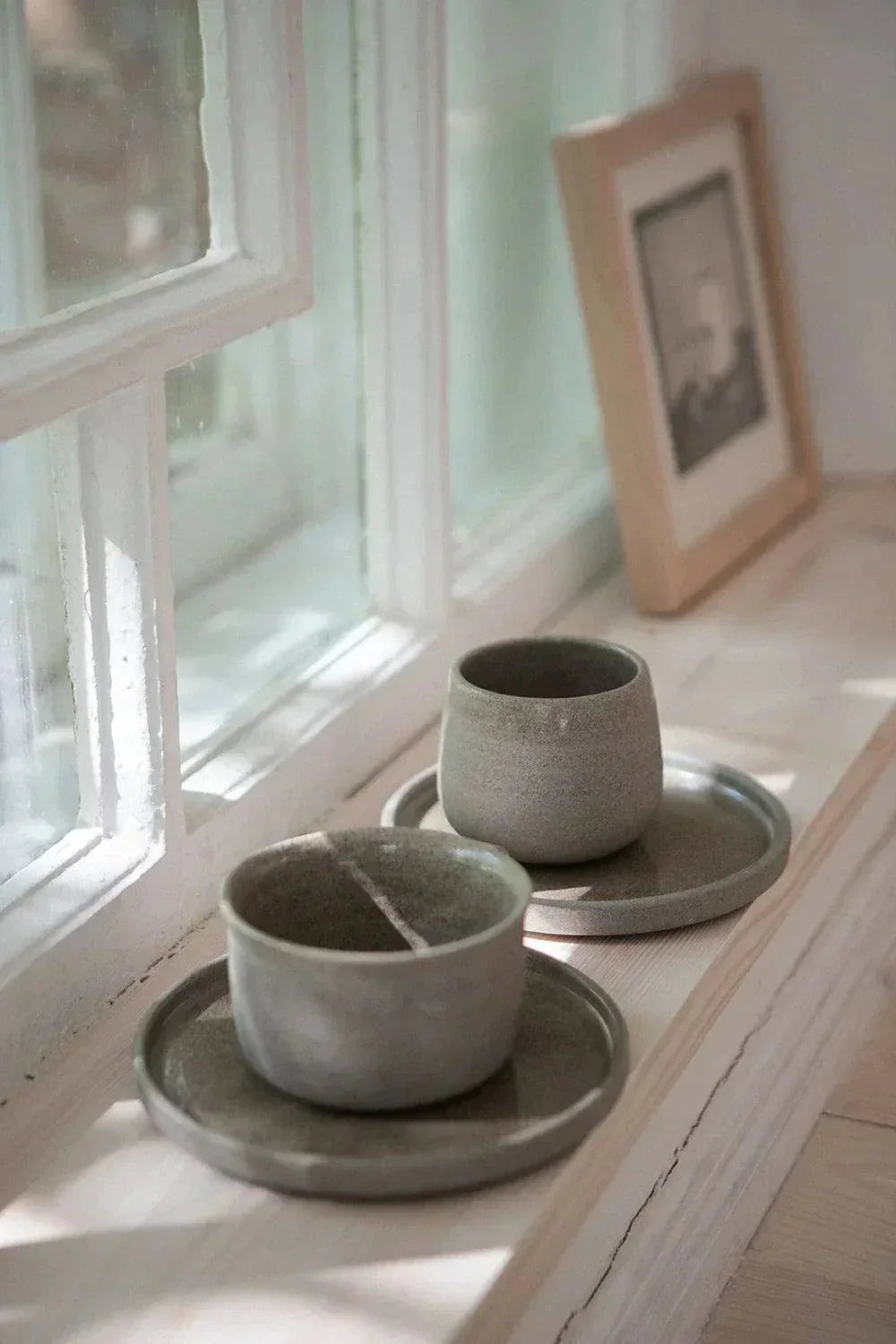 Handmade Stoneware Coffee Cup in muted gray-green, with a matte, textured exterior, glazed interior, and matching saucer.