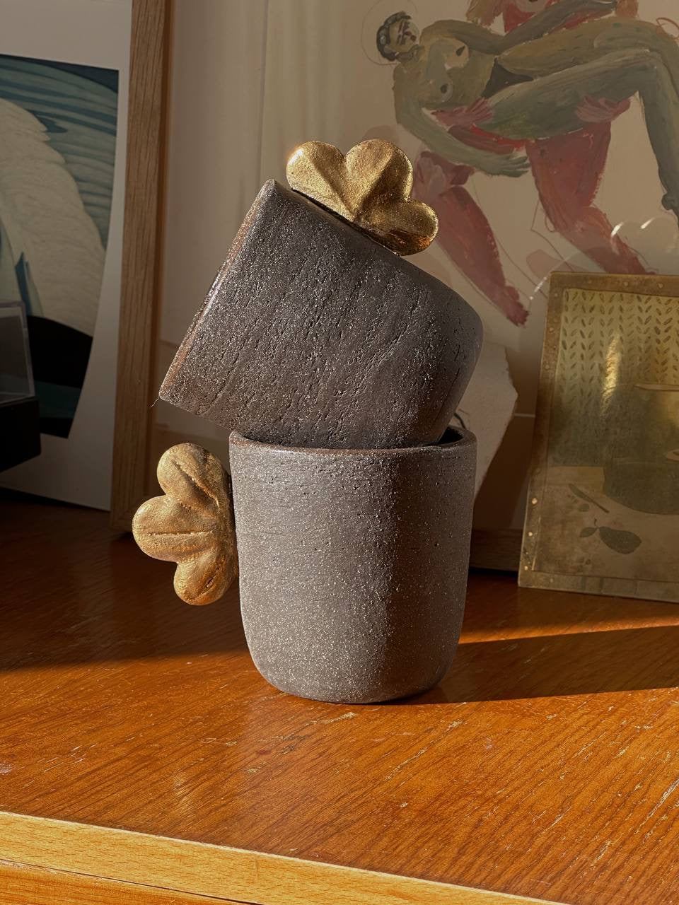 Handmade Stoneware Coffee Cup in rough charcoal-brown stoneware, with sculptural gold leaf accents and a matching lid.