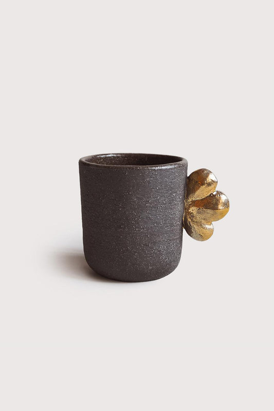 Handmade Stoneware Coffee Cup in dark brown textured clay, with a glossy gold flower-shaped handle detail.