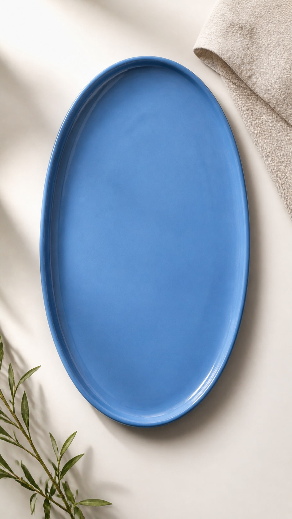 Oval Serving Platter in smooth blue glazed porcelain, with a raised rim and elongated shape for serving.