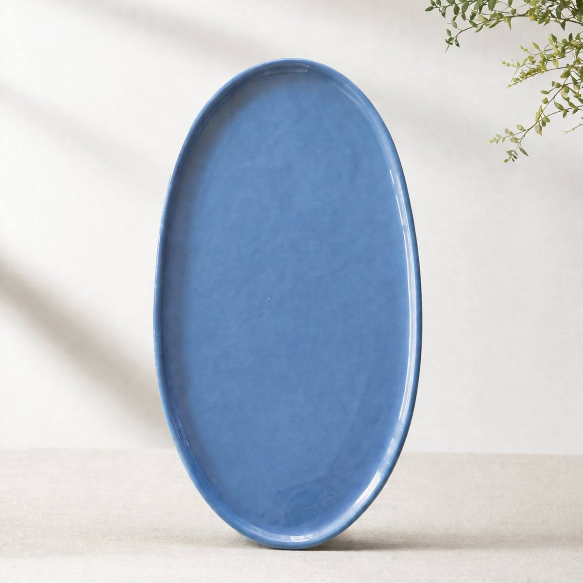Oval Serving Platter in glossy blue porcelain, with a smooth glaze, gently raised rim, and organic rounded edges.
