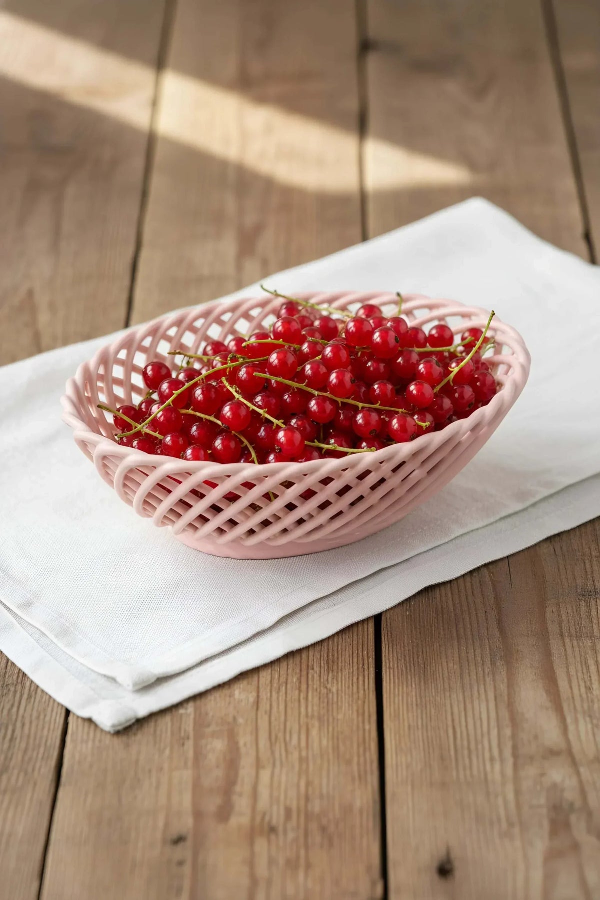 Hand-Woven Ceramic Basket in soft pink glazed ceramic, with an oval shape and open interlaced design.