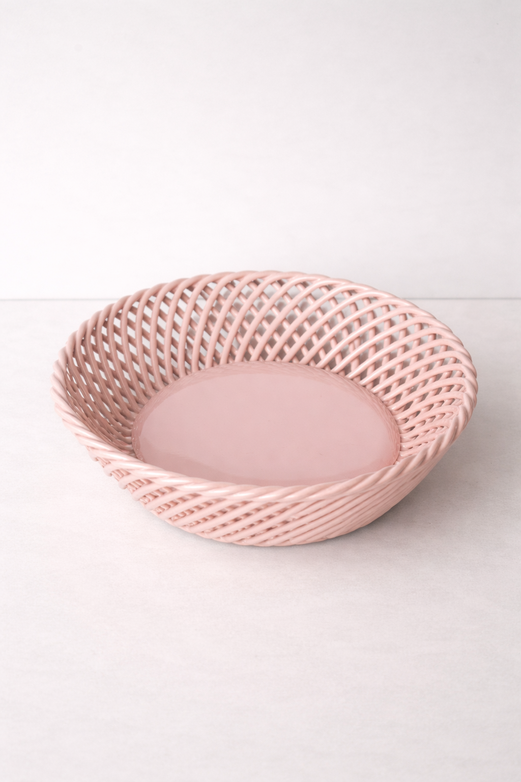Ceramic Round Hand-Woven Basket in glossy pink porcelain, with an airy open-weave lattice rim and smooth round base.