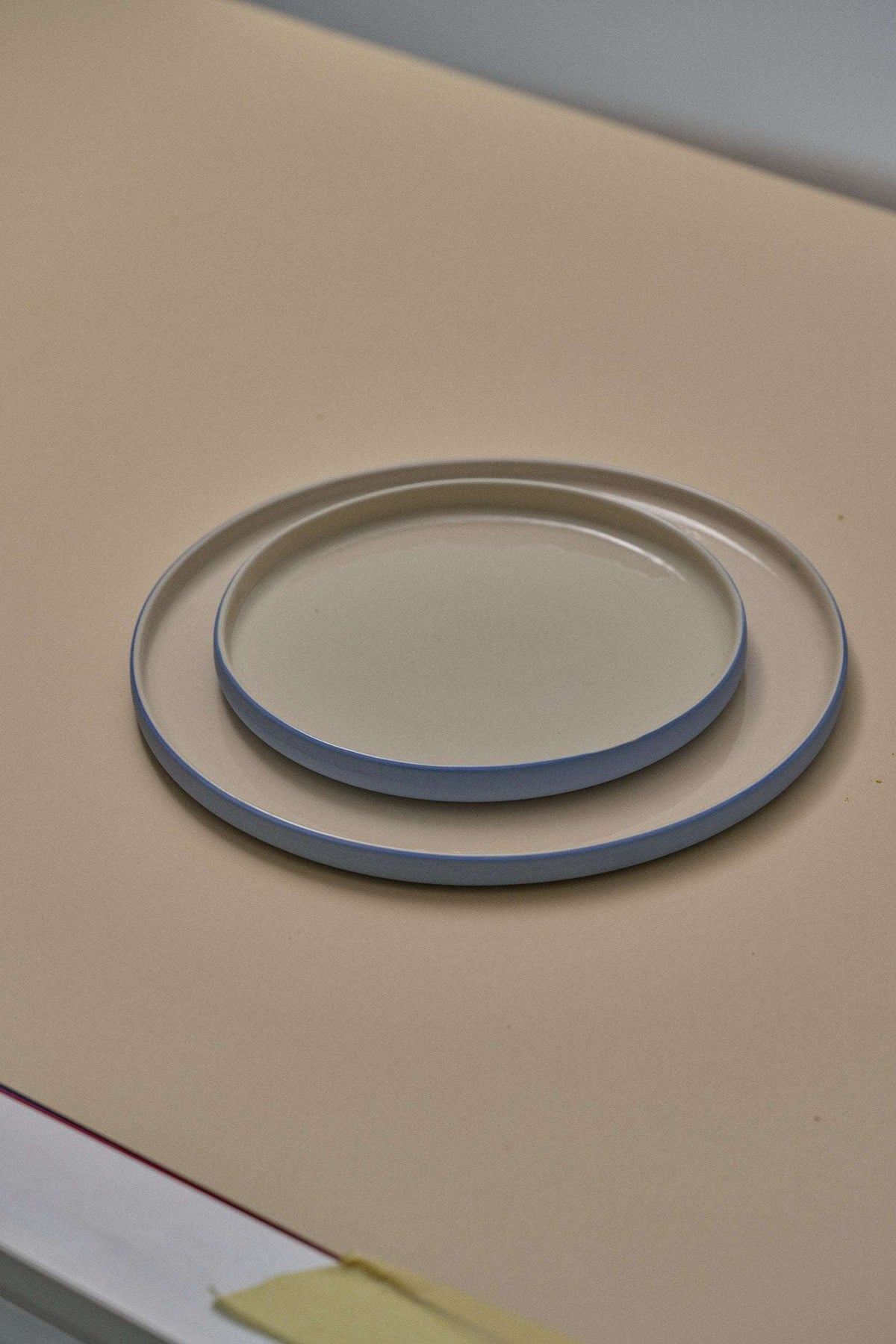 Handmade Blue Porcelain plates in pale blue with smooth glazed surfaces and a narrow contrasting dark rim.