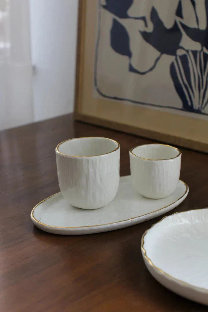 Handmade Porcelain oval serving platter in off-white with a textured relief surface and delicate gold rim.