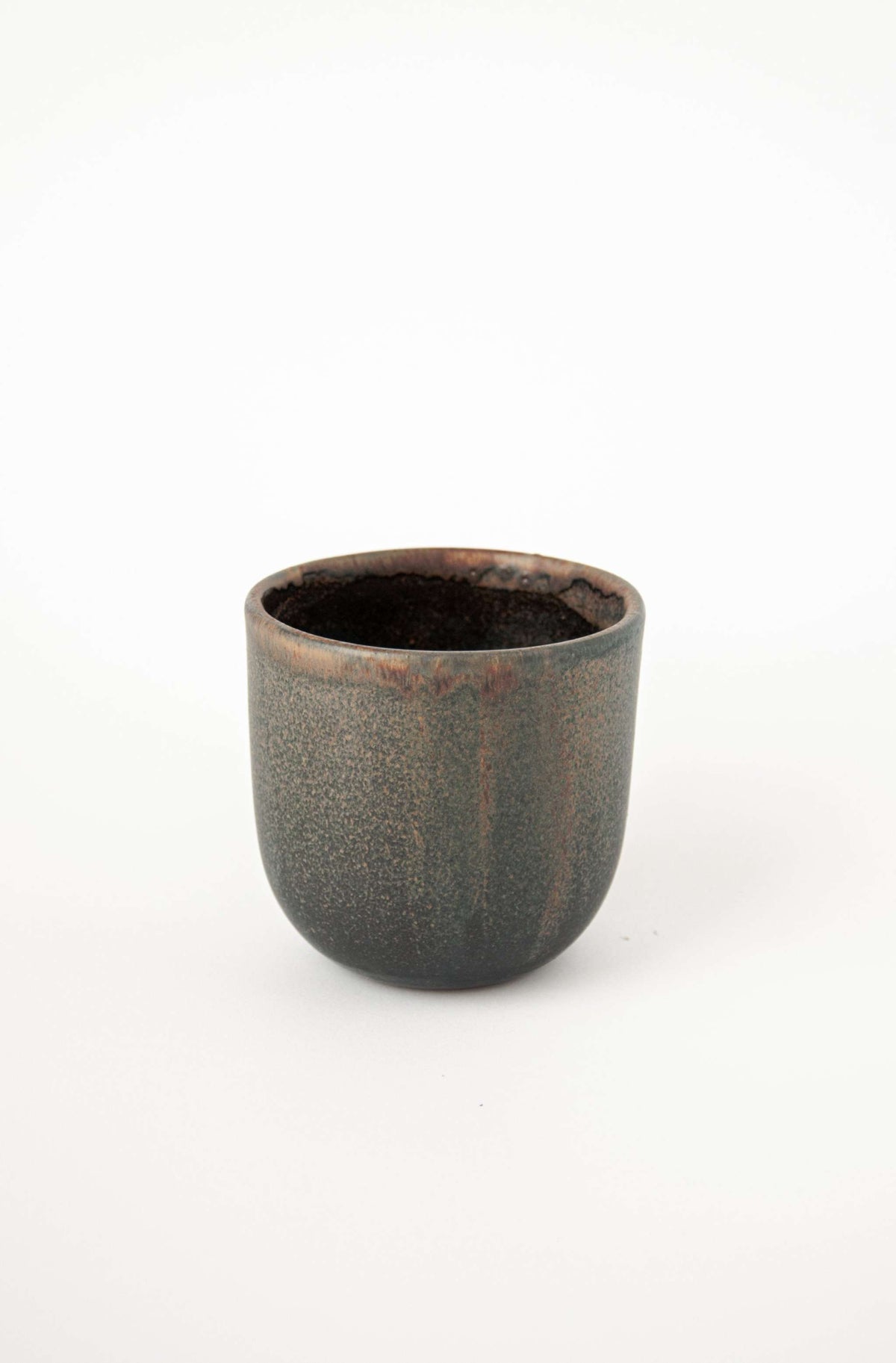 Rust stoneware coffee cup with organic edges and unique reactive glaze, handmade in Ukraine.