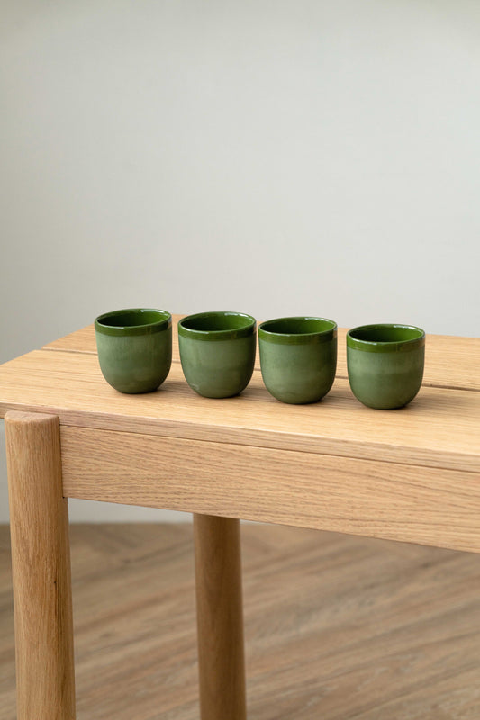 Handmade green porcelain espresso cup with exposed clay and glossy interior