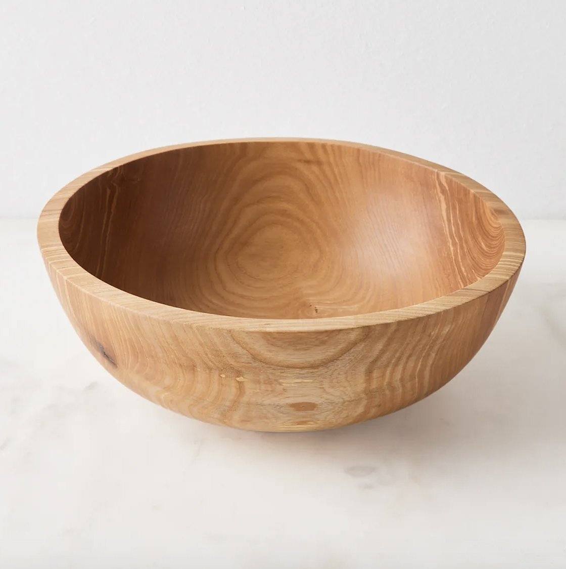 Wooden nesting bowl set with a warm honey-brown finish, natural swirling grain, and a smooth, rounded carved bowl.
