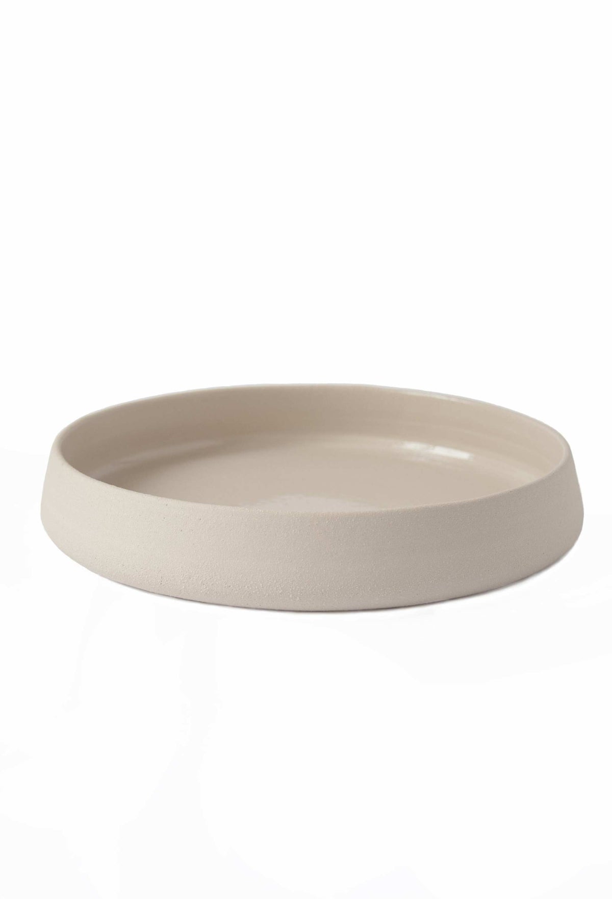 Handmade stoneware dinner plates with high sides and transparent glaze showcasing rustic texture and glossy interior