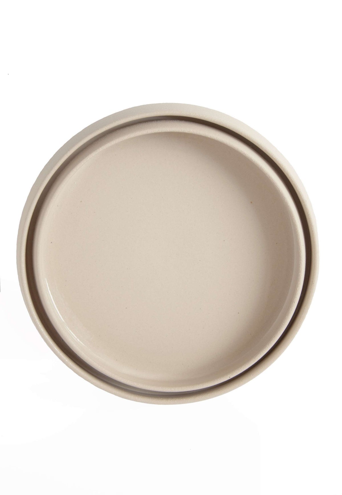 Handmade stoneware dinner plates with high sides and transparent glaze showcasing rustic artisan texture