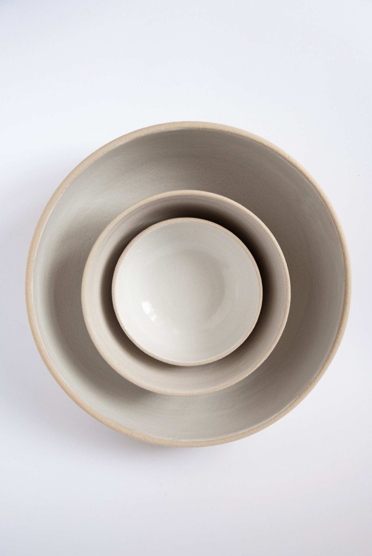 Handmade stoneware large fruit bowl with white glazed interior, rough textured exterior, ideal for fruits and kitchen use