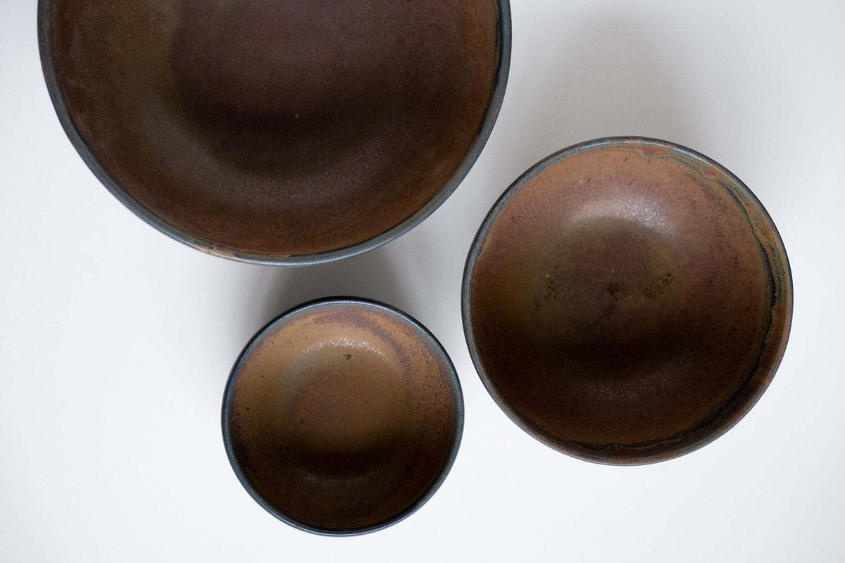 Rust stoneware nesting bowl set with matte brown-black glaze and unique swirls, stackable and handmade in Ukraine