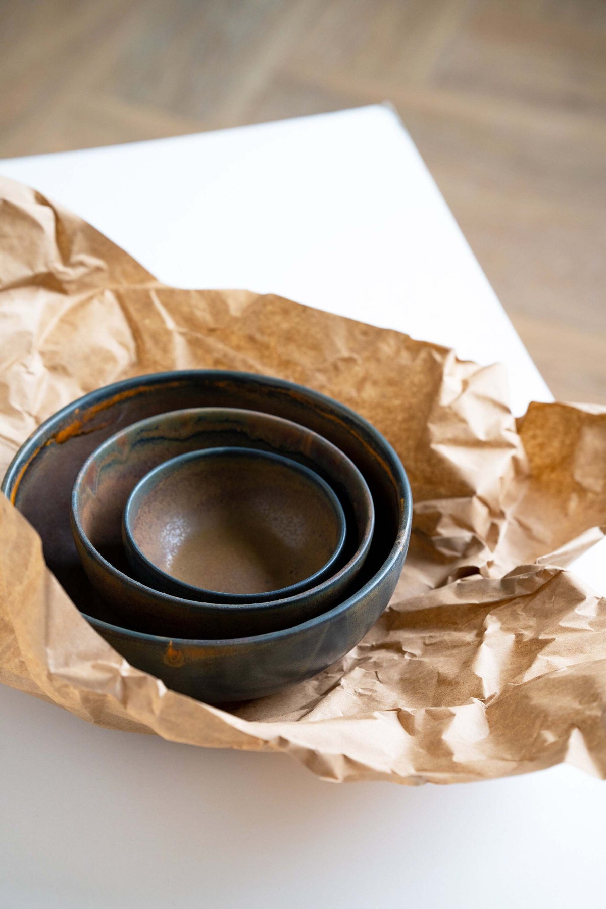 Rust stoneware nesting bowl set with matte brown-black glaze and subtle swirls, handmade in Ukraine