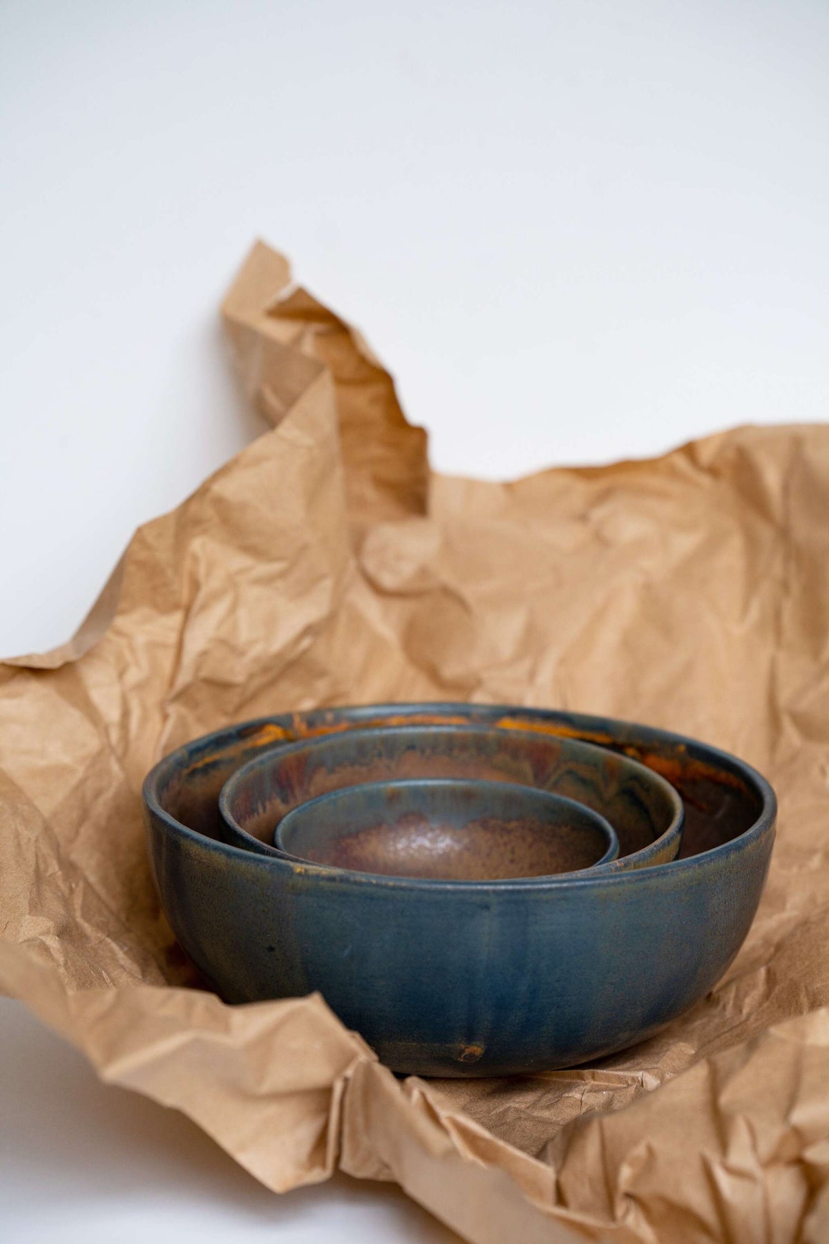 Rust stoneware nesting bowl set with matte brown-black glaze and unique swirls, handcrafted in Ukraine