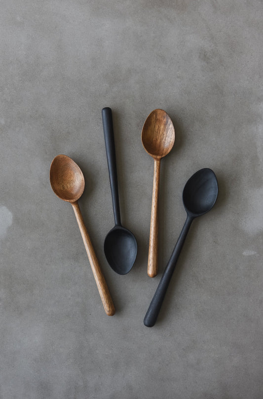 Hand-carved walnut wood spoon with straight handle, showcasing natural grain and warm color