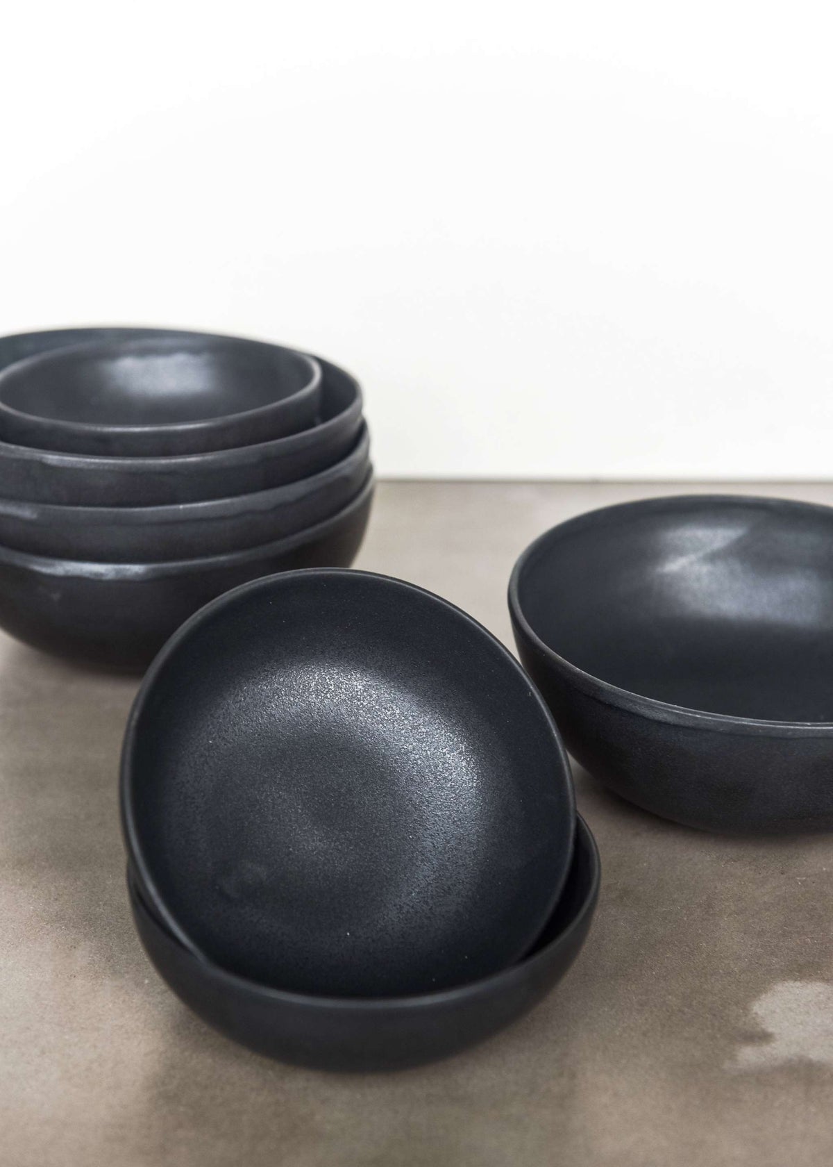 Handmade black matte stoneware bowl with organic curves and lighter rim, food-safe and lead-free, dishwasher and microwave safe.